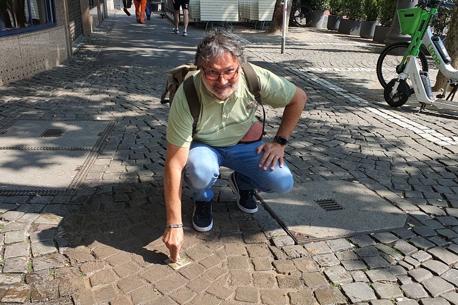 Ibrahim Basalamah putzt den frisch verlegten Stolperstein / Foto: Kalle Kubatschka/DAV