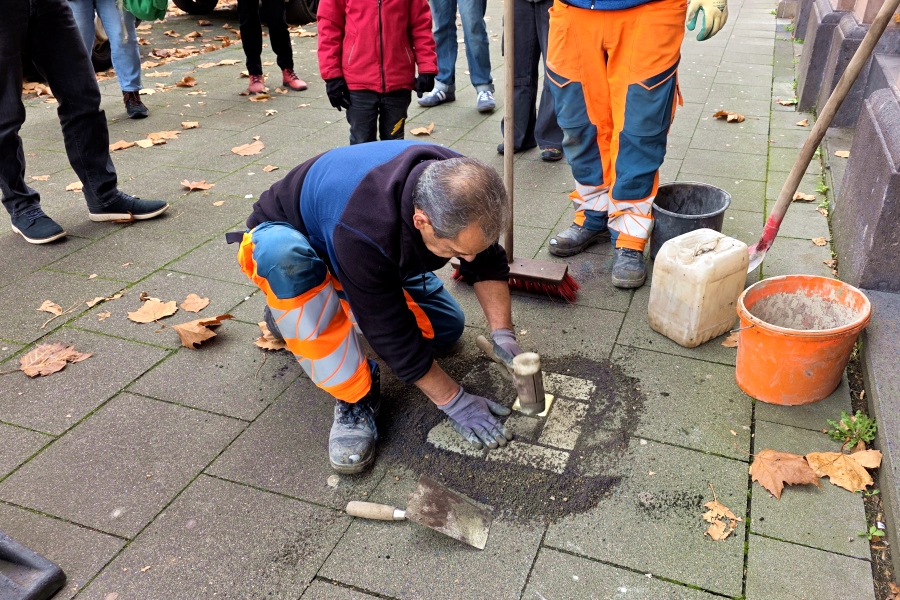 Mitarbeiter der Stadt K%C3%B6ln verlegen den Stolperstein / Foto: Kalle Kubatschka/DAV